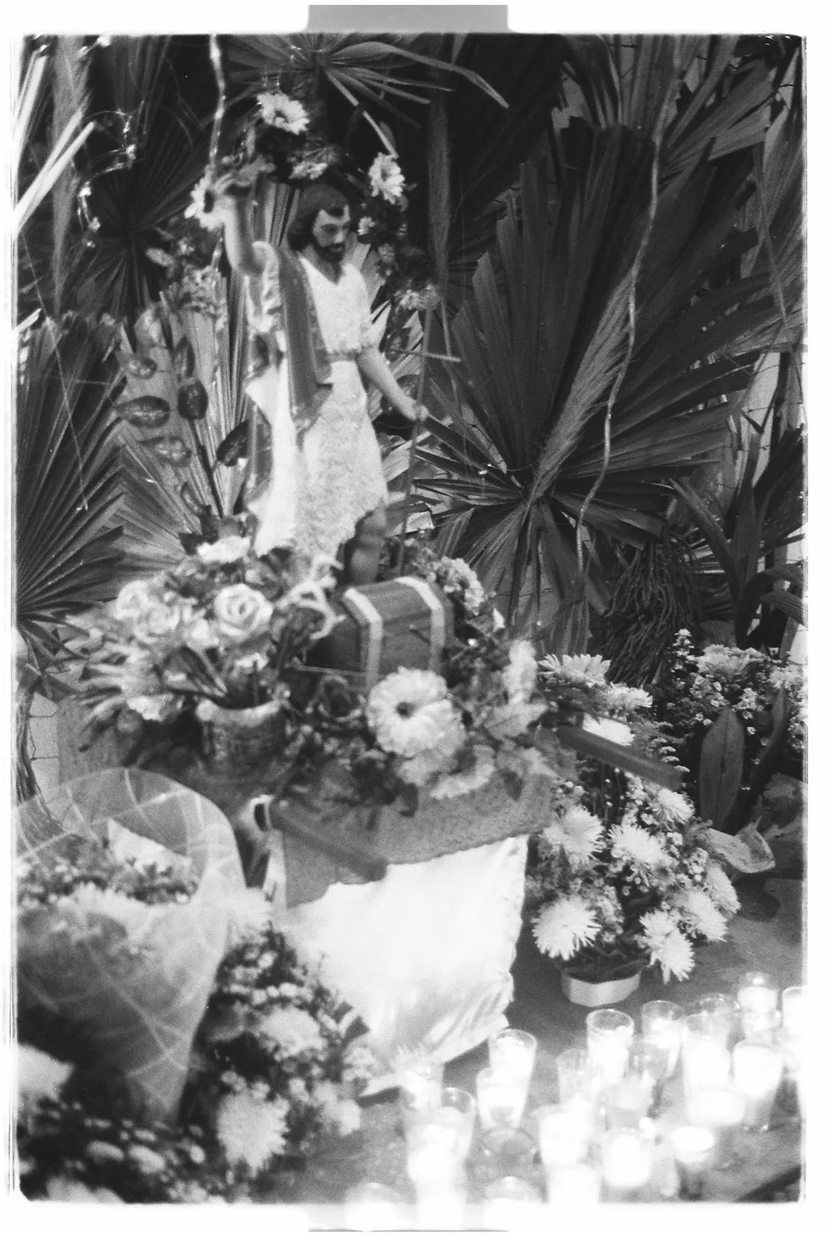 Altar con flores, velas y una figura religiosa